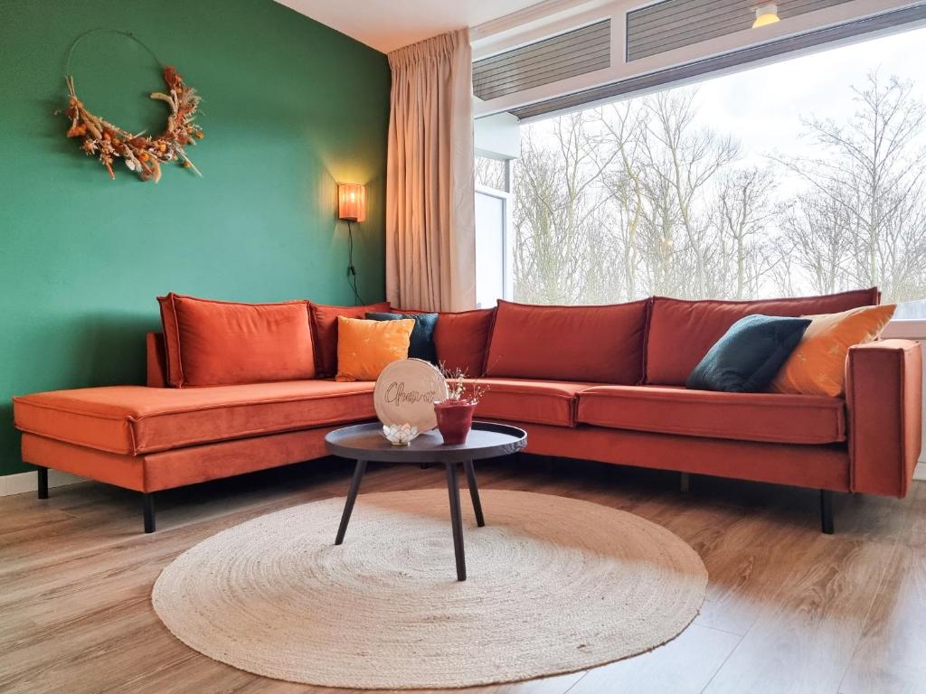 a living room with a red couch and a table at Vakantie appartement Chava WE09 in Westkapelle