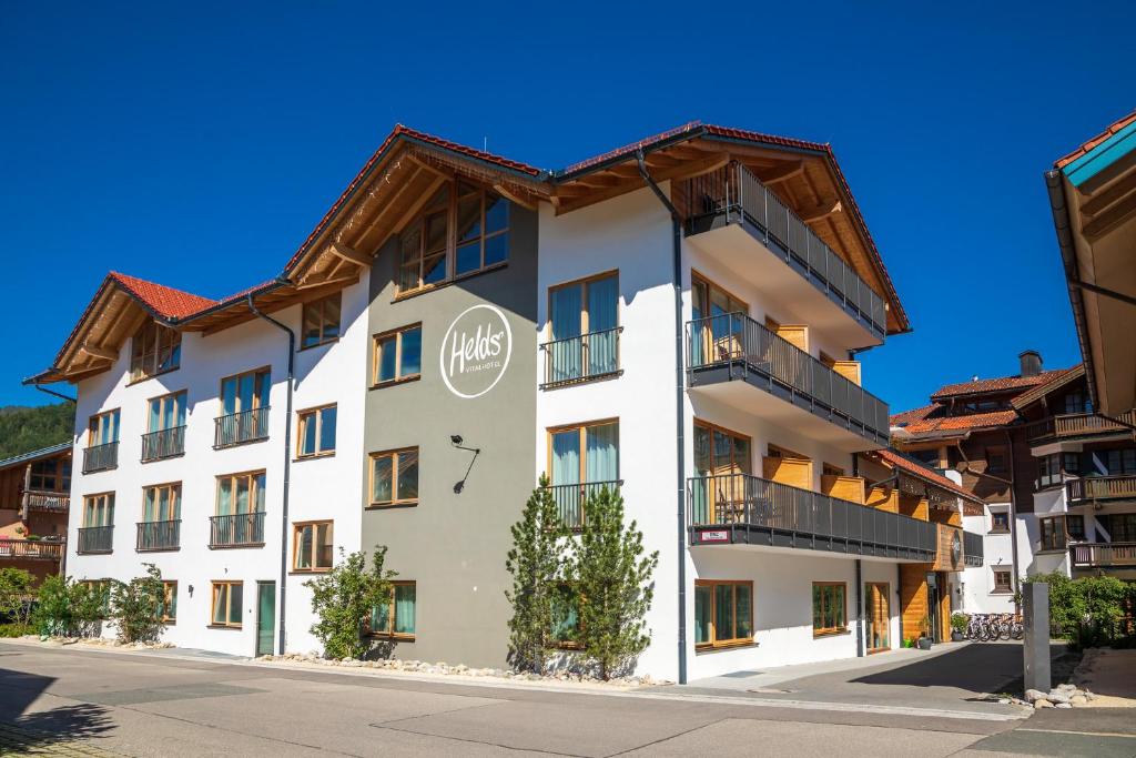 a white building with a brown roof at HELDs Vitalhotel in Ruhpolding