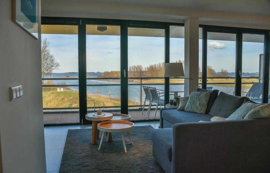 a living room with a couch and a view of the water at Appartement aan jachthaven met zicht op Veerse meer in Arnemuiden