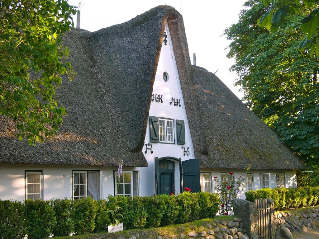 ein strohgedecktes Cottage mit einem Strohdach in der Unterkunft Weidemannhaus Wohnung 6 "Galerie" in Keitum