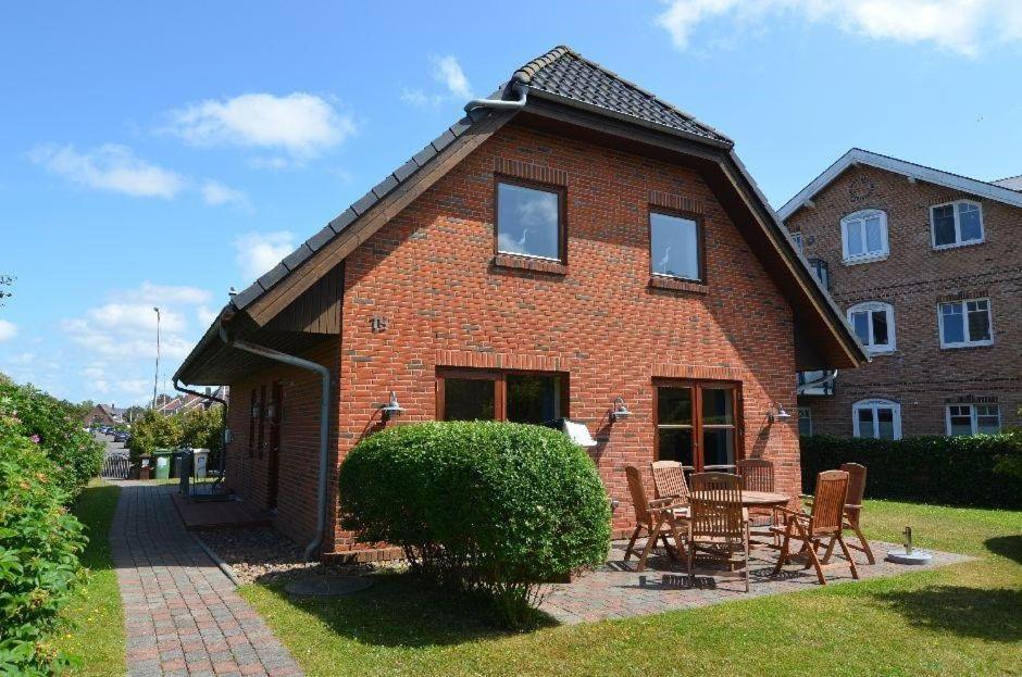 a brick house with a table and chairs in front of it at Theodor Heuss in Westerland
