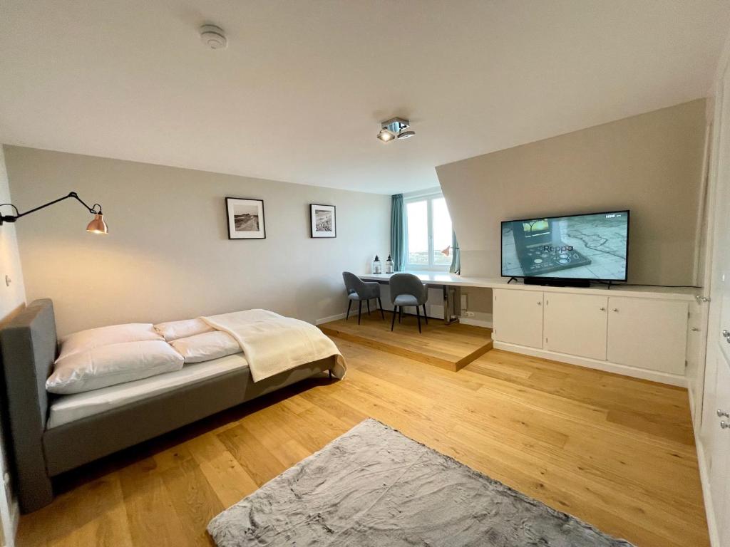 um quarto com uma cama e uma televisão de ecrã plano em Norderhof Kliffsand 19 em Kampen