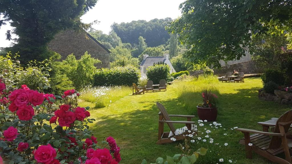 a garden with benches and flowers in the grass at Hostellerie de la Poterne in Moncontour
