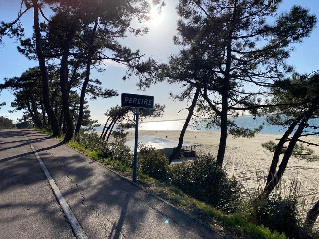 un panneau indiquant la rue sur le côté d'une route à côté d'une plage dans l'établissement Appartement de standing 4 étoiles plage Pereire à pied 100m, à Arcachon