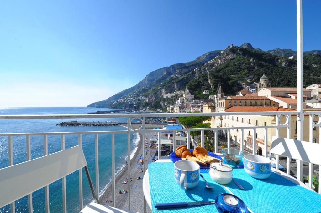 a table on a balcony with a view of a beach at Dolce Vita B in Amalfi