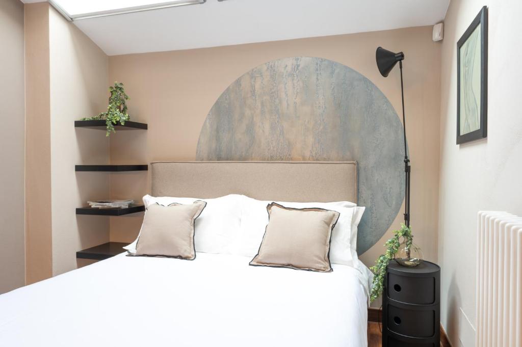 a bedroom with a bed and a painting on the wall at Petra Apuana Luxury Apartment in Pietrasanta