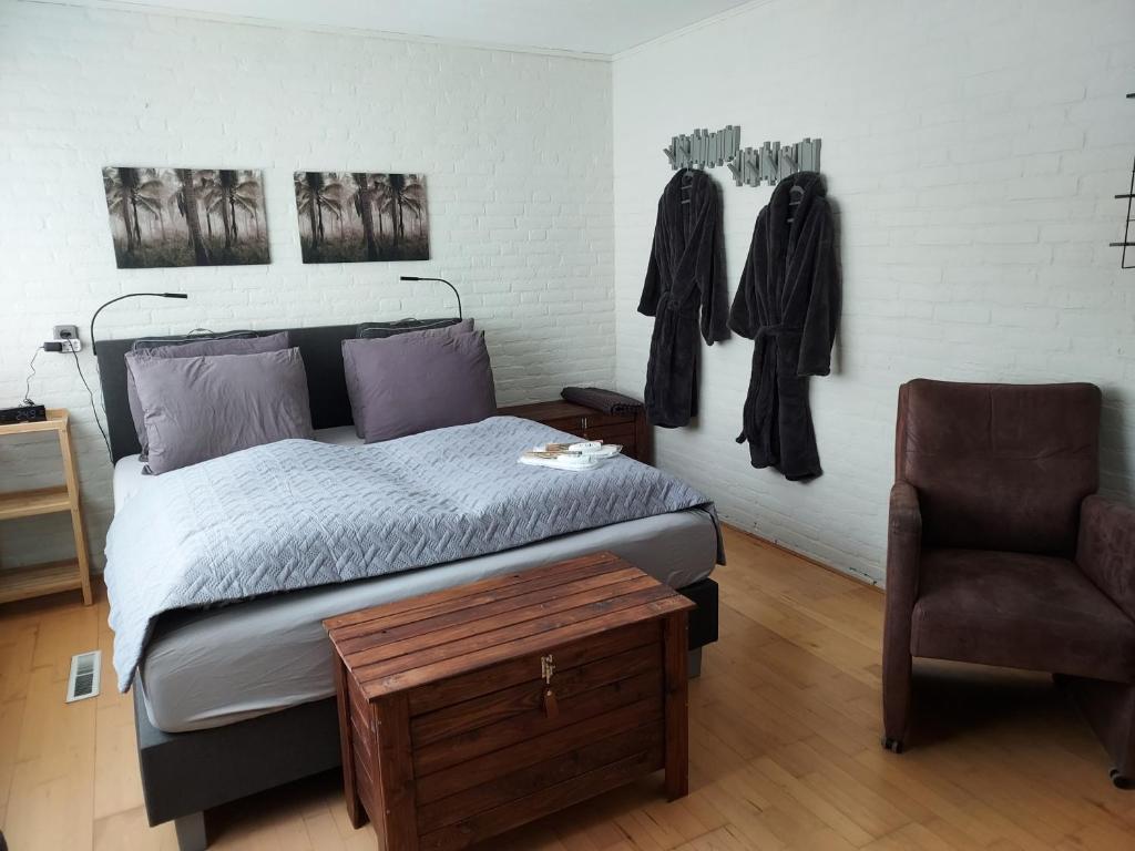 1 dormitorio con 1 cama y 1 silla en B&B de Sluis, en Rosmalen