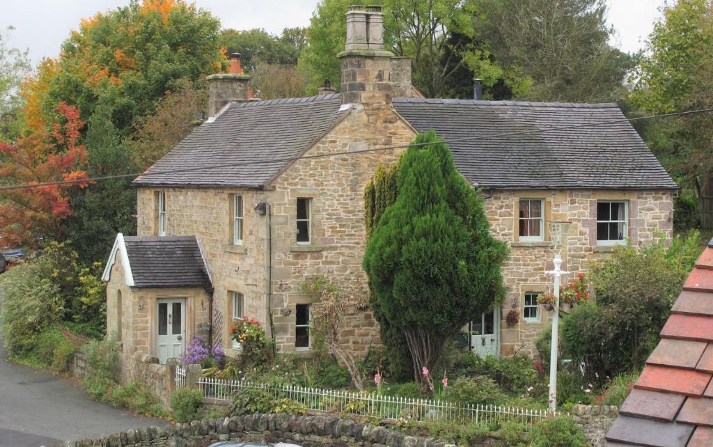 uma antiga casa de pedra com um telhado preto em Sunnyside Bed and Breakfast em Longnor