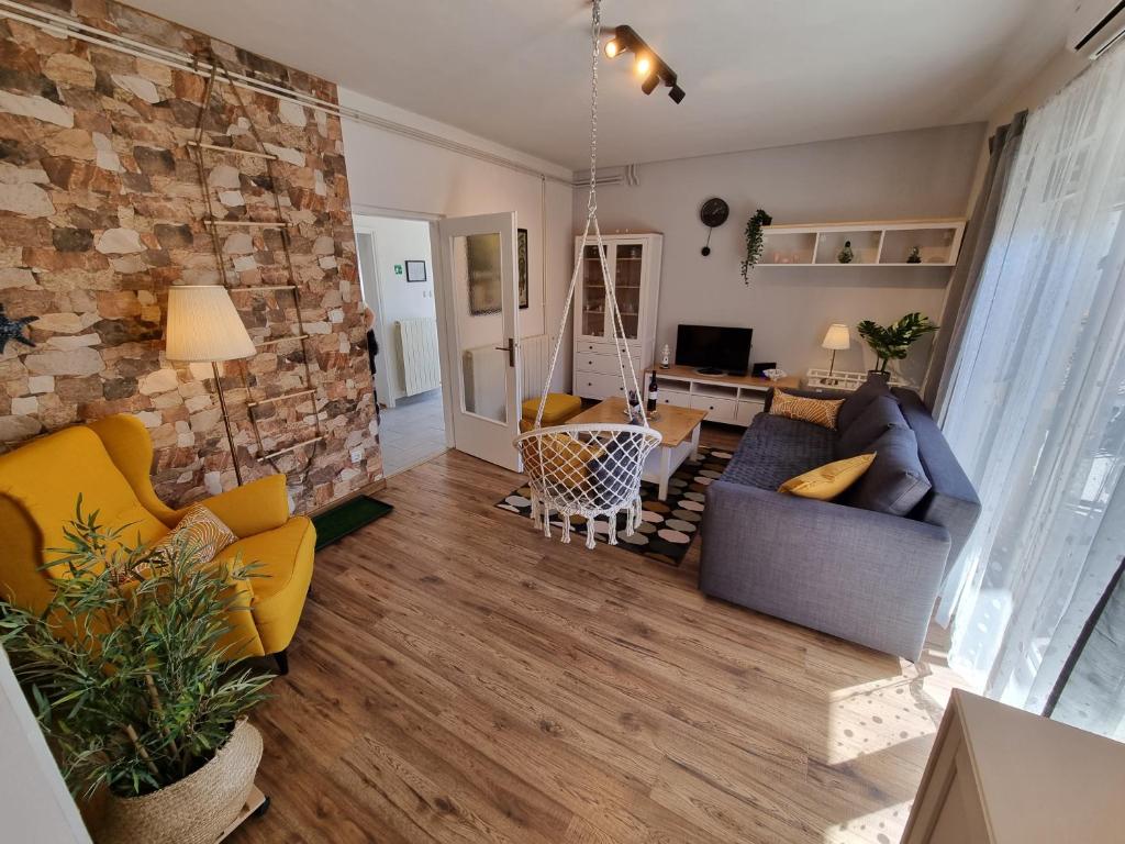 a living room with couches and a stone wall at Apartment ANAMARIJA BR. 1 in Crikvenica