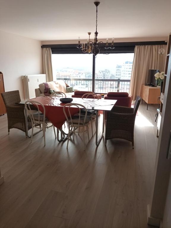 a living room with a dining room table and chairs at Apartment Havenzicht in Blankenberge