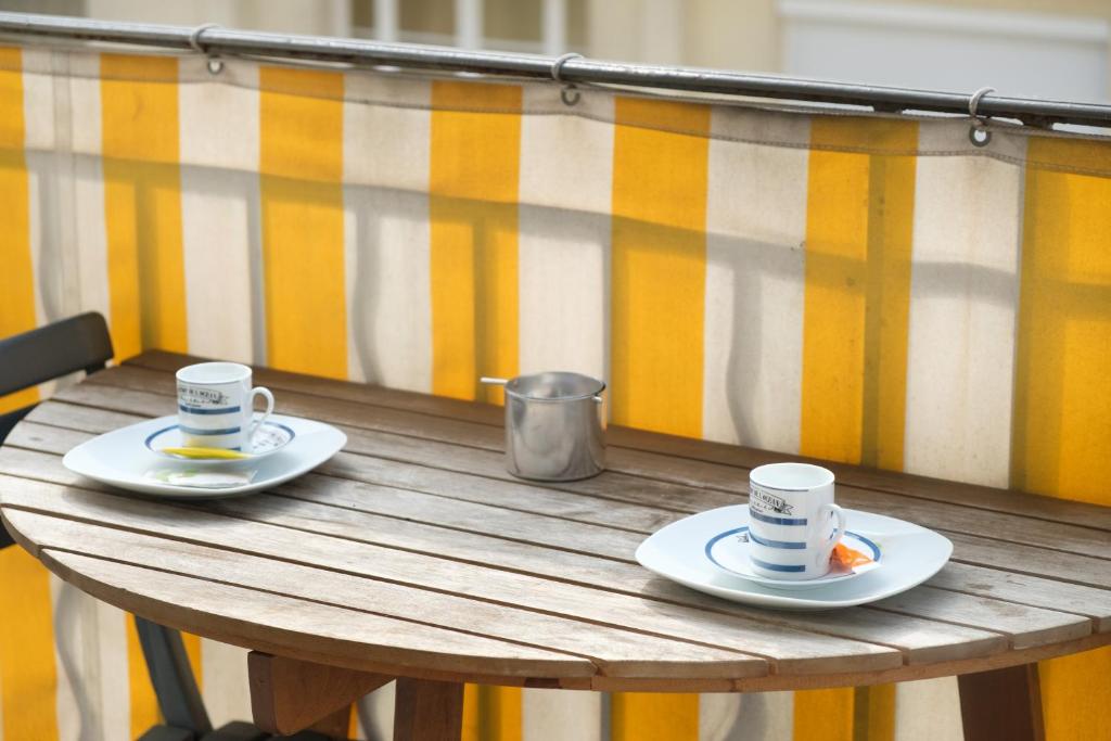 カンヌにある3 pièces- Vieux port- Terrasse - Parking Possibleの木製テーブルに座ったコーヒー2杯