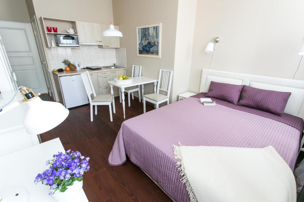 1 dormitorio con cama y mesa con sábanas moradas en Gedimino House, en Vilna