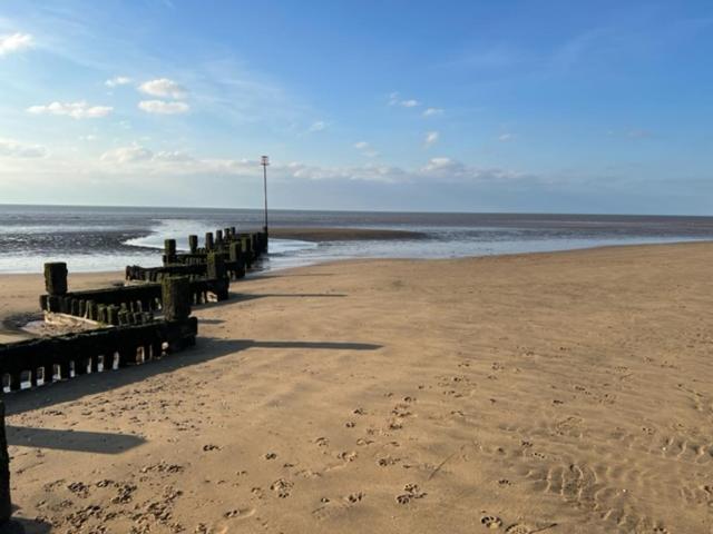 a beach with a row of wooden posts on the beach at Gone To The Beach Flat 1 in Hunstanton