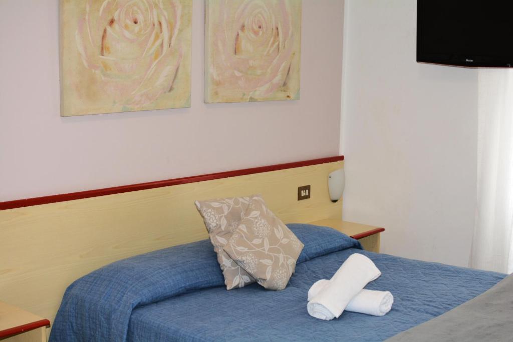 a bedroom with a blue bed with a white pillow at HOTEL LA MADUNINA in Varazze