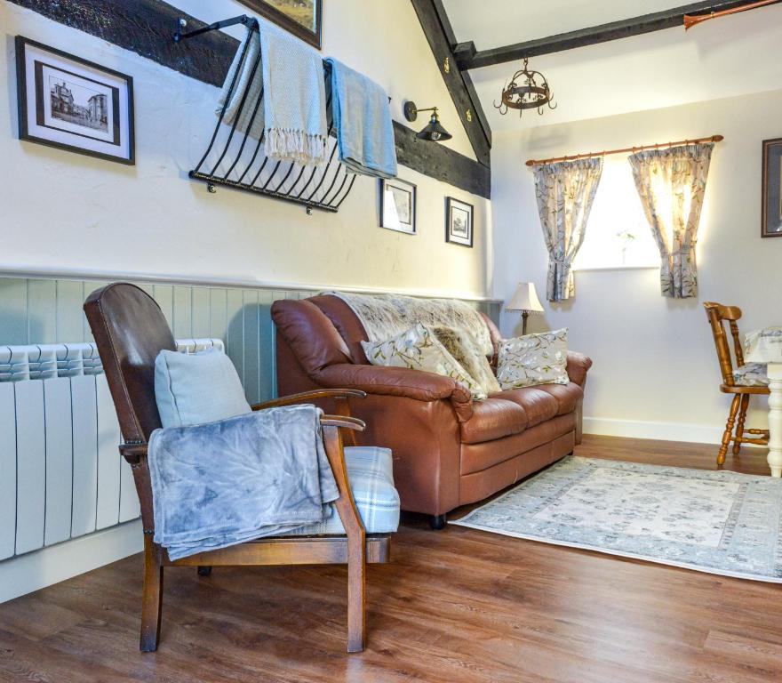 a living room with a couch and a chair at The Old Milking Parlour in Llandovery