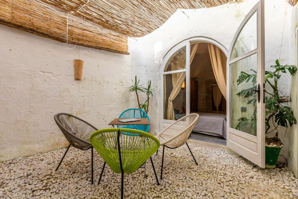 タリファにあるAzogue suites con patio privadoのパティオ(椅子、テーブル、窓付)