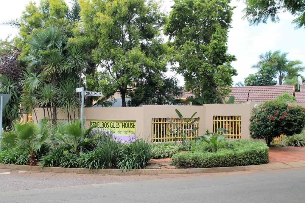 Ein Zaun mit einem Schild, das Landschaftsgärtnerei liest. in der Unterkunft Sekelbos Guesthouse in Pretoria