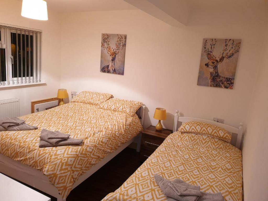 1 Schlafzimmer mit 2 Betten und 2 Bildern an der Wand in der Unterkunft Homebird Property - Conway House in Leeds