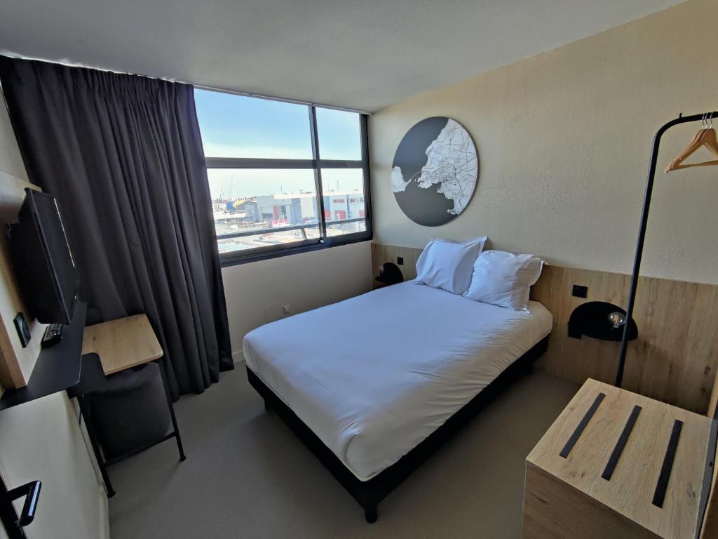 a hotel room with a bed and a window at B&B HOTEL La Rochelle Centre Les Minimes in La Rochelle