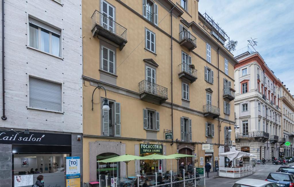 budynek z zielonymi parasolami na ulicy miejskiej w obiekcie Central Pop House vicino a Piazza San Carlo w Turynie