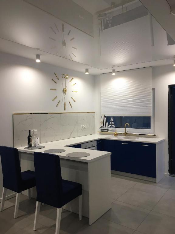 a kitchen with a counter and a clock on the wall at Domki Meer Dziwnówek in Dziwnówek