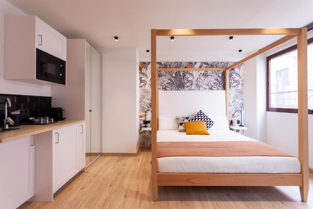 1 dormitorio con cama con dosel y cocina en Welldone Sierpes Boutique, en Sevilla