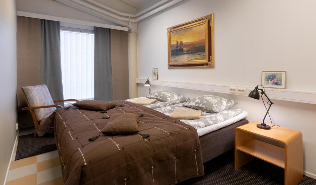 una camera con un grande letto di Hostel Eduskunta a Kauhajoki