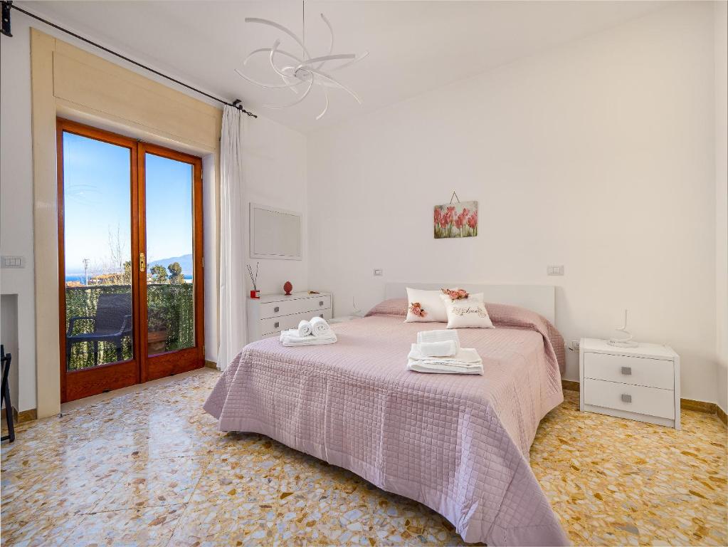 um quarto branco com uma cama e uma janela em ENEA apartment in Sorrento center em Sorrento