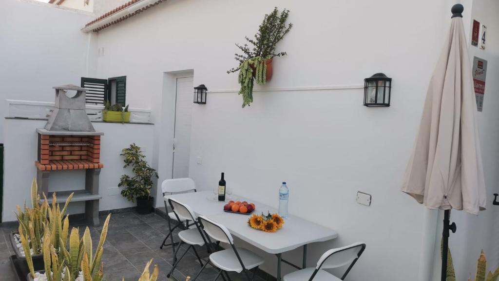 eine weiße Terrasse mit einem weißen Tisch und Stühlen in der Unterkunft CHALET CON JACUZZI CLIMATIZADO, BARBACOA Y CERCA DE LA PLAYA in Abades