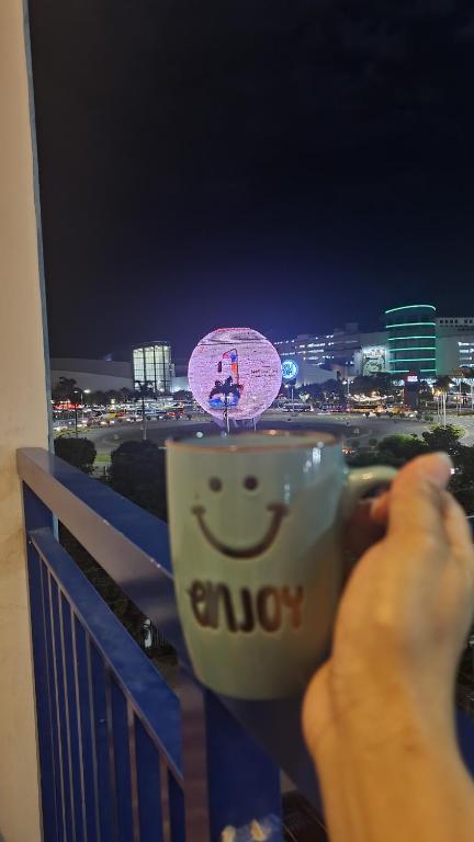 a person holding a coffee cup with a smile on it at Sea Residences EZBedz in Manila