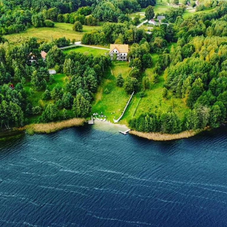an aerial view of a house on an island in the water at Hosteria na Mazurach in Dąbrówno