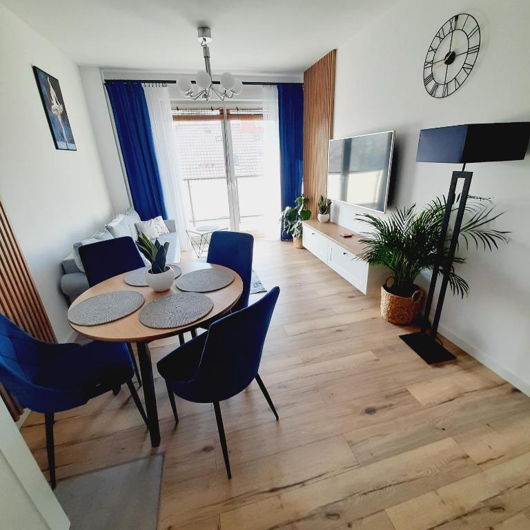 uma sala de estar com uma mesa e cadeiras e uma televisão em Lux Apartment parking gratis em Złotów