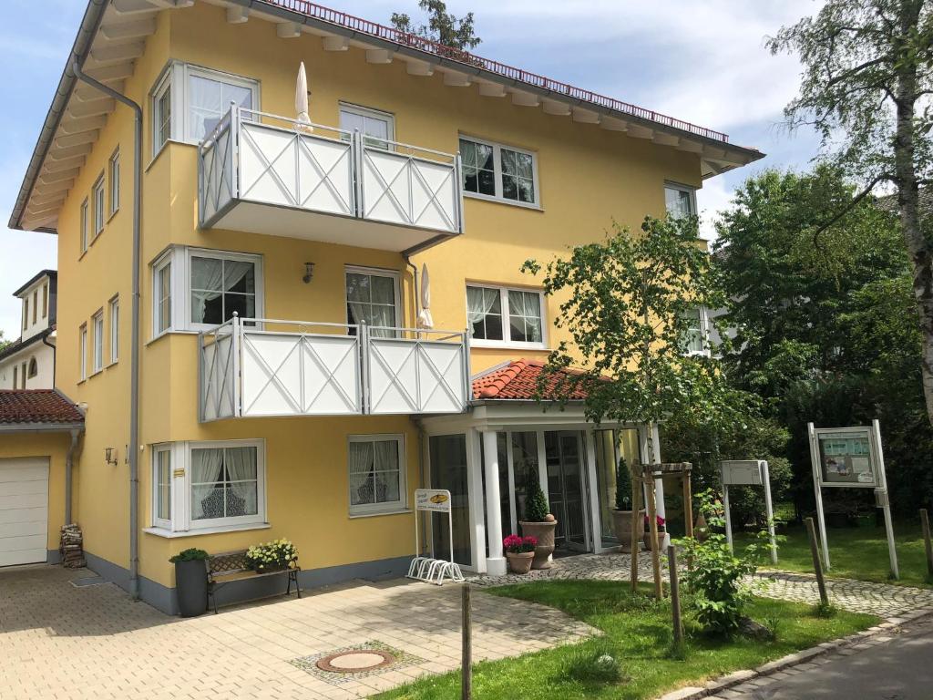 ein gelbes Haus mit weißen Balkonen auf einer Straße in der Unterkunft Birkenhof-Birke in Bad Wörishofen