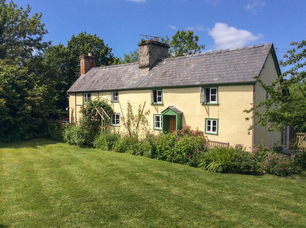 uma grande casa branca com um jardim de relva em Denbigh Hall em Leominster