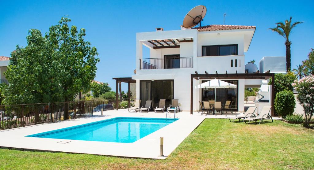 a villa with a swimming pool in front of a house at Villa Hera in Ayios Theodhoros
