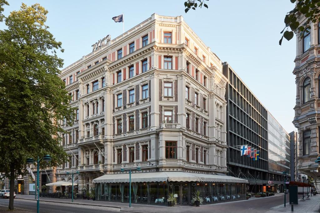 a large white building on the corner of a street at Hotel Kämp in Helsinki