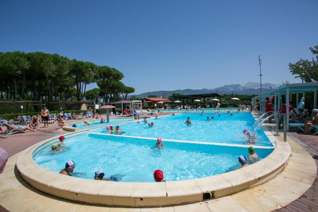 eine Gruppe von Personen in einem Schwimmbad in der Unterkunft International Holidays Luxe House Pool Beach-Lerici-Cinque Terre-Liguria Case Vacanze in Touristic Village River in Ameglia