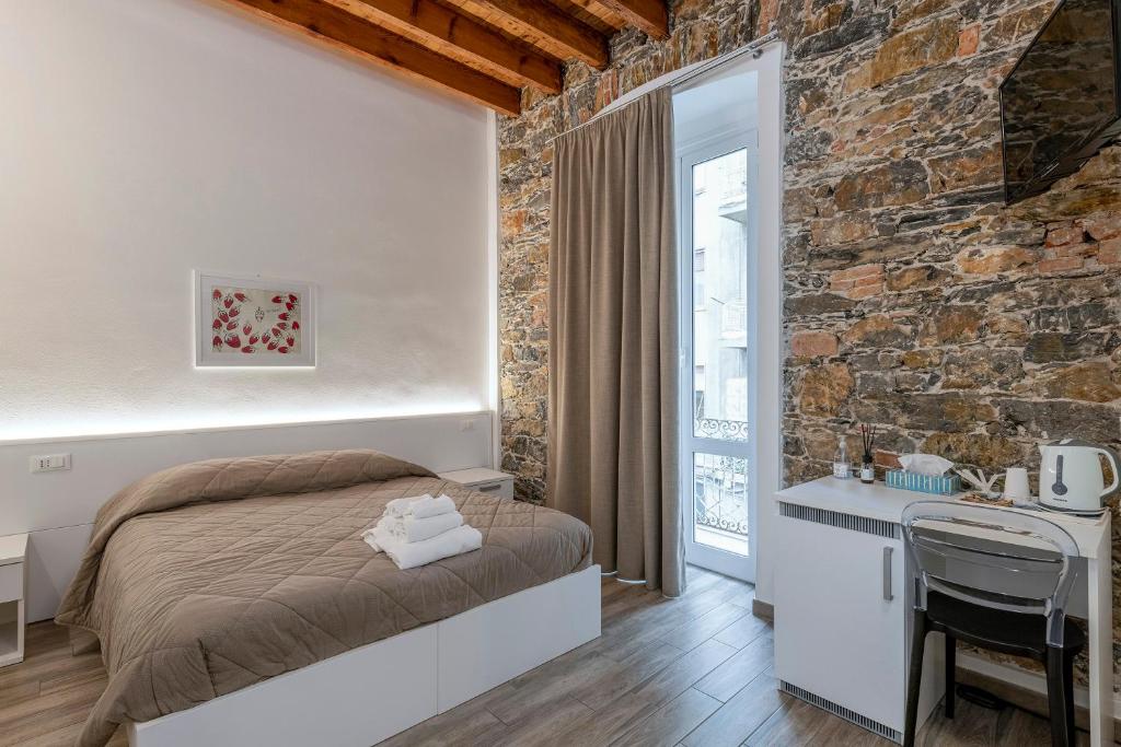una camera con letto e parete in pietra di La casa di Mattia a La Spezia