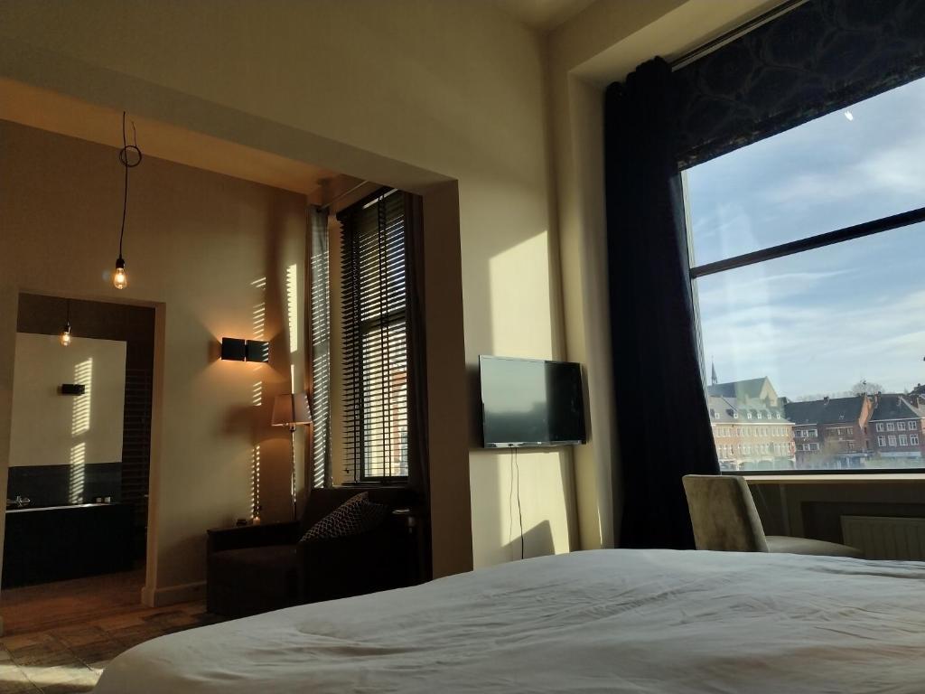 a bedroom with a bed and a window with a tv at Peter House in Nivelles