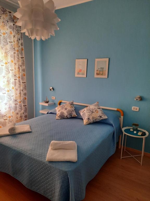 a blue bedroom with a bed with two towels on it at Affittacamere Mirella in Pineto