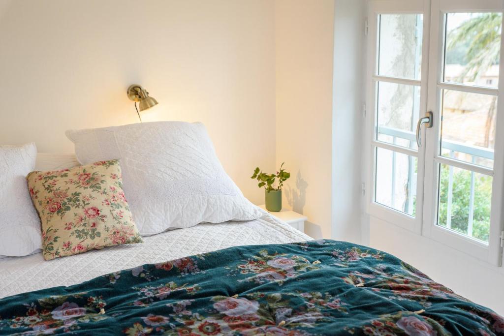 a bedroom with a bed with a pillow and a window at Lilie House in Bormes-les-Mimosas