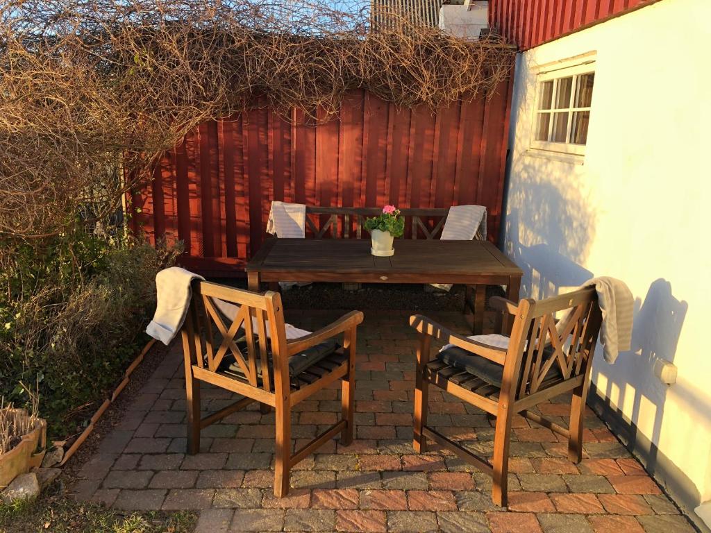 einen Holztisch und zwei Stühle auf einer Terrasse in der Unterkunft Noble Hill in Ängelholm