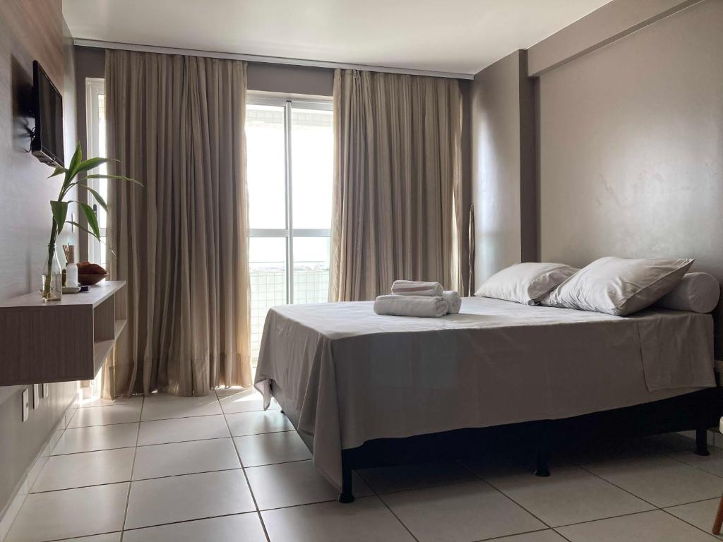 1 dormitorio con cama y ventana grande en Studio Comfort West Flat, en Mossoró