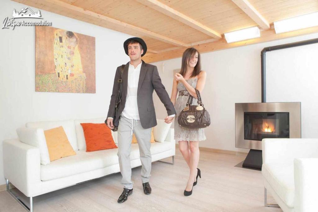 Ein Mann und eine Frau stehen im Wohnzimmer in der Unterkunft Appartamenti Green esclusivo riservato soleggiato in Livigno