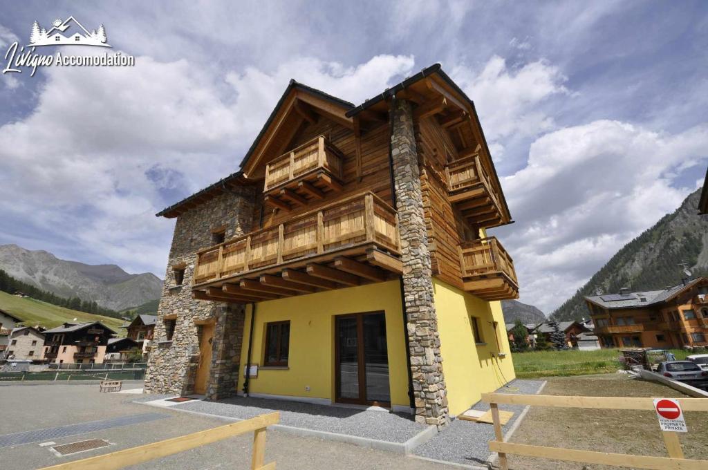 a house with a wooden roof on top of it at Eco House la tua scelta consapevole stilosa in Livigno