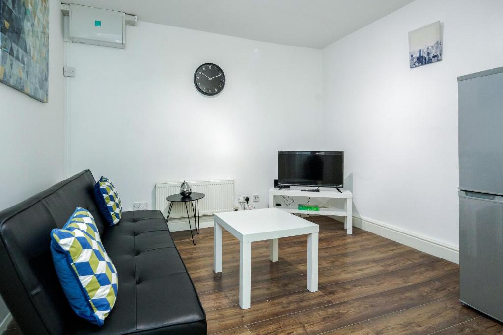 a living room with a couch and a table at Charming 1-Bed Basement Apartment in Lewisham in London