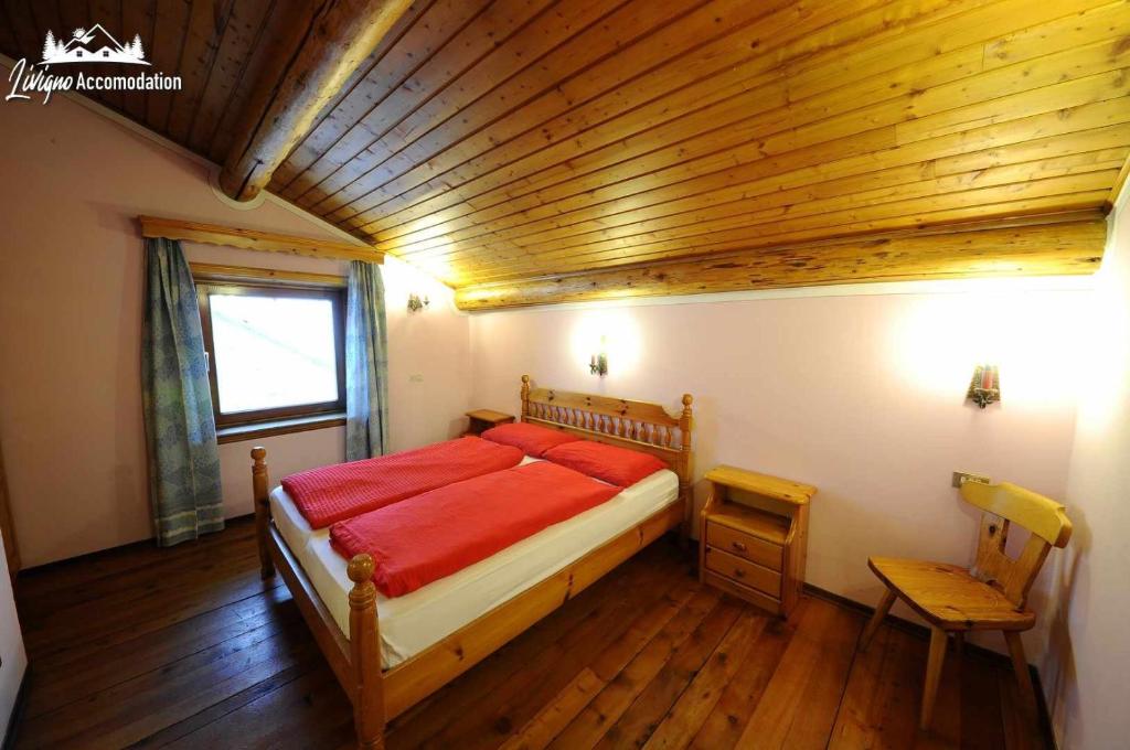 a bedroom with a bed and a wooden ceiling at Appartamento Feloi vicino alle piste da sci in Livigno
