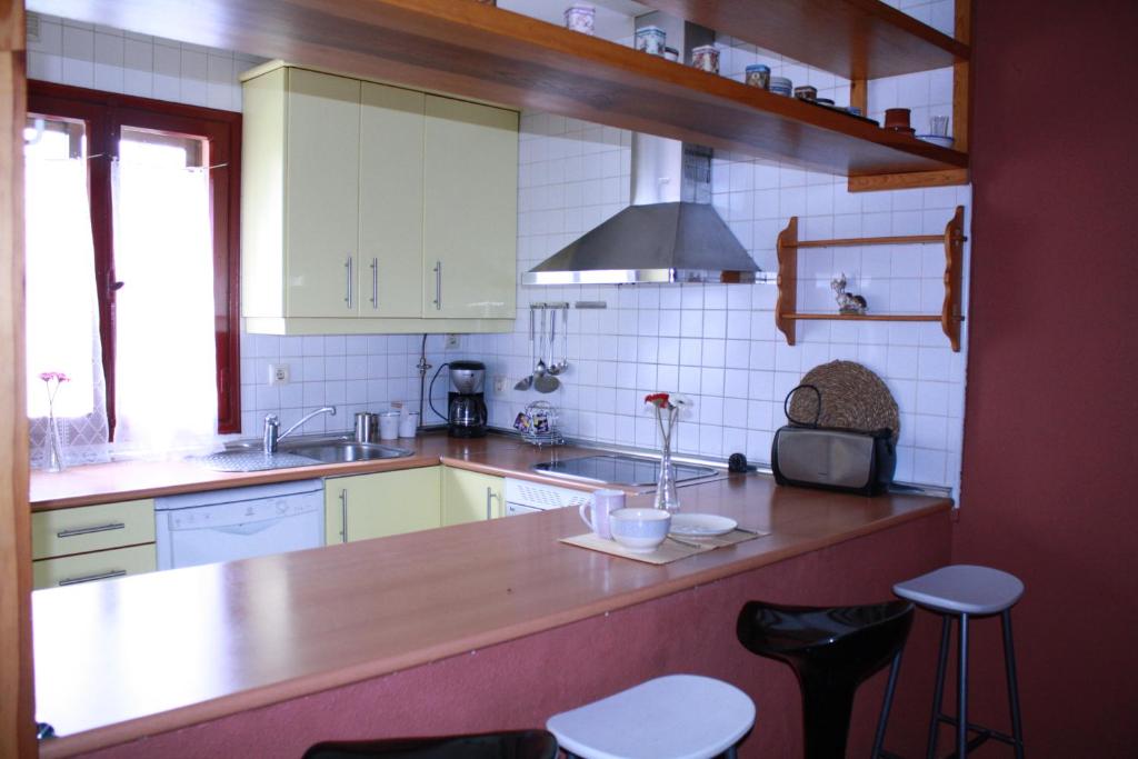 a kitchen with a counter and some stools in it at La Cerca de Torrecaballeros, a 10 min de Segovia in Torrecaballeros