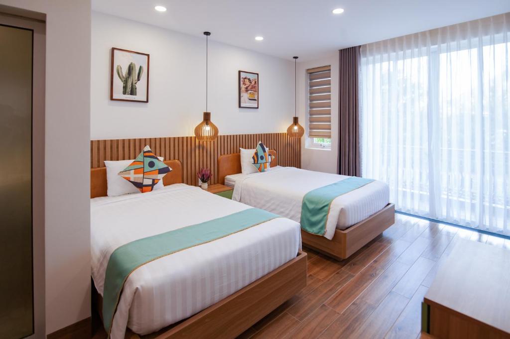 um quarto de hotel com duas camas e uma janela em The View Hotel em Cam Lâm