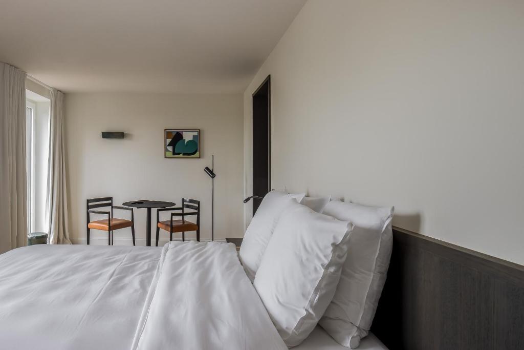 a bedroom with a bed and a table with chairs at Hotel Nenuphar in Ghent